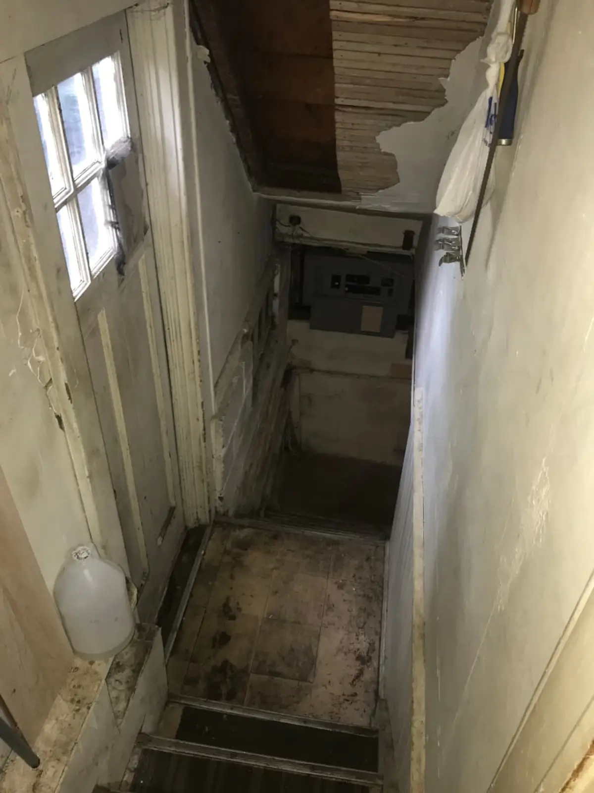 Selling a house in a flood zone in Baldwin: basement stairwell with crumbling, stained walls