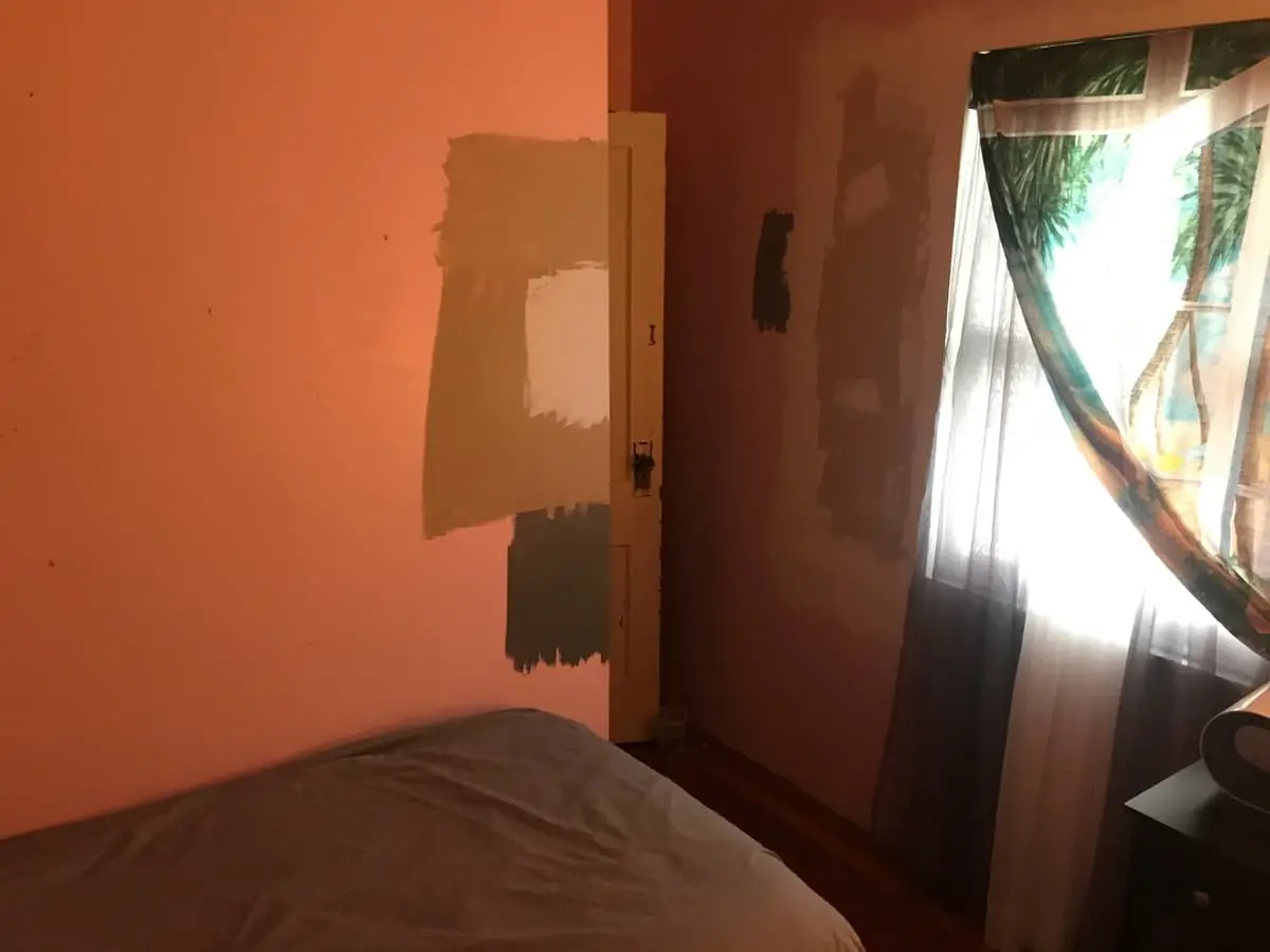 Selling a fire-damaged house in Baldwin: bedroom with patched, half-painted orange walls