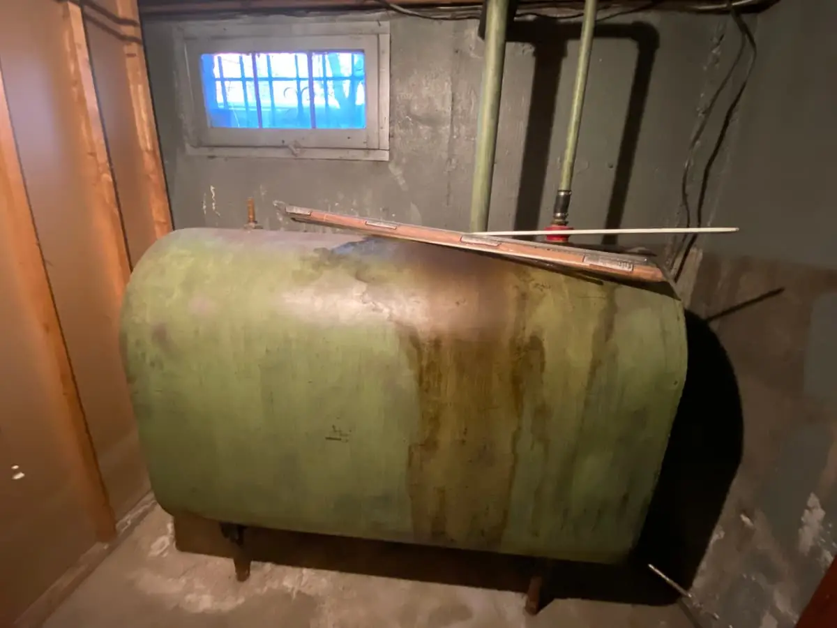 Selling a house with an oil tank in Baldwin: old oil tank in the corner of a basement