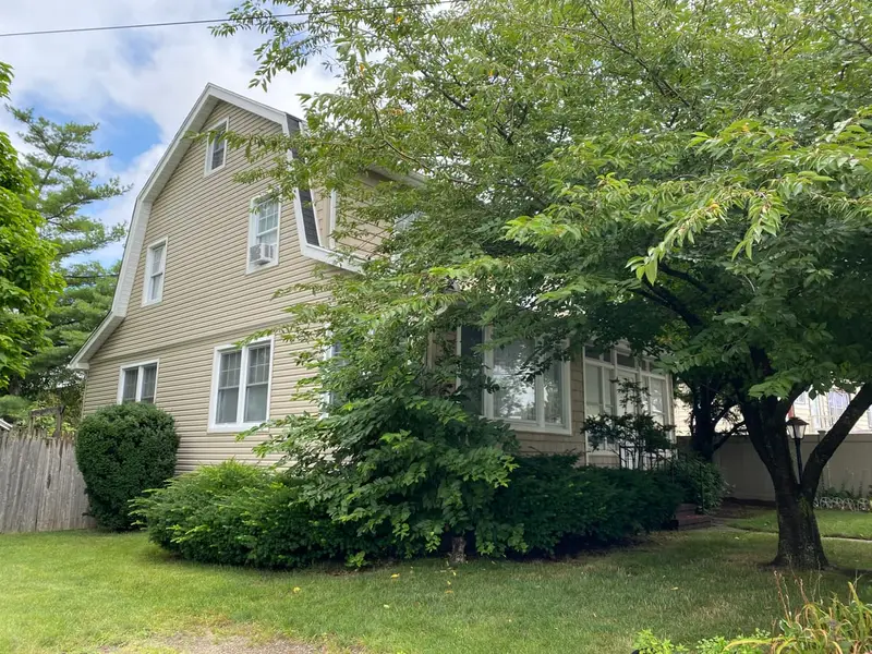 Two-story colonial behind a leafy front-yard tree, Baldwin, NY
